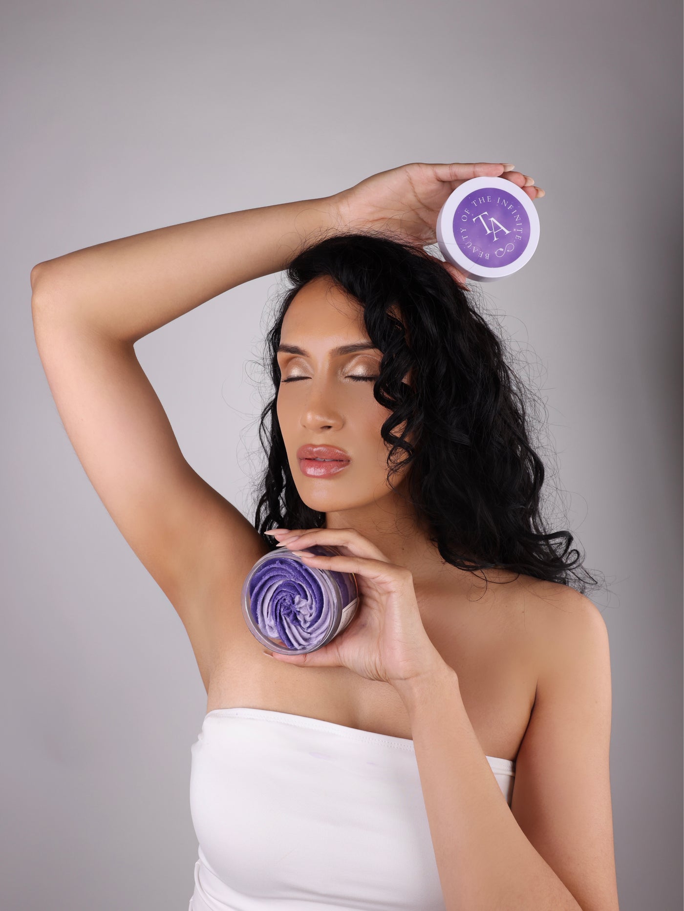 Woman holding The Arcturian Lavender Whipped Scrub with a gray background